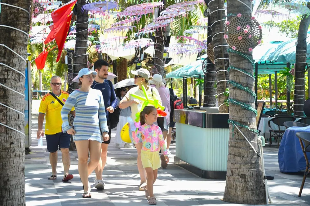 On October 3, foreign parent-child tourists enjoyed themselves at Dadonghai Tourism Area in Sanya. Photo by Zhang Yuehe