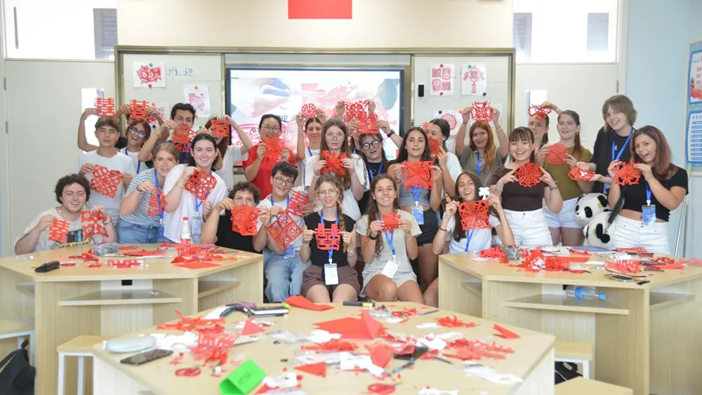 On July 5, in Sanya, Hainan, Italian teenagers displayed the paper-cut window decorations they made themselves. Photo by Zhang Yuehe