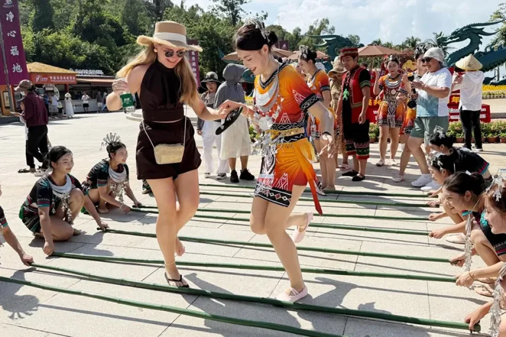 On October 1, foreign tourists experienced a bamboo pole dance featuring Hainan Li ethnic characteristics at the Nanshan Cultural Tourism Zone in Sanya. (Photo provided by the Nanshan Cultural Tourism Zone in Sanya)